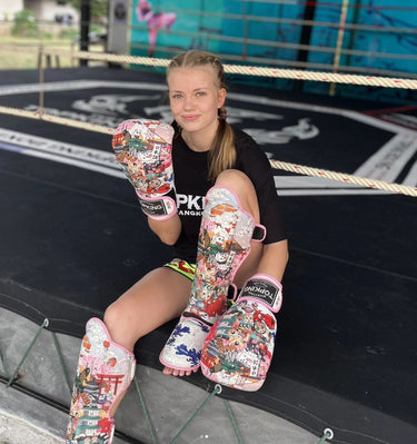 Muay Thai fighter Marie Ruumet in Top King USA gear - wearing Pink boxing Gloves and Pink shin guards with Japanese Culture design