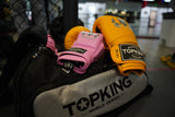 Pink and Yellow gloves on Top King backpack bag in the gym