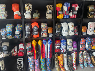 Top King Gloves and Top King Shin Guards on display on a wall