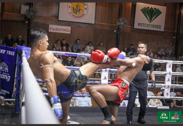 Muay Thai fighter landing a push kick during a stadium bout