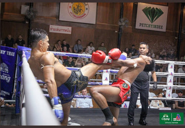 Muay Thai fighter landing a push kick during a stadium bout